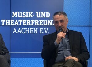 100 Jahre, das ist schon ‚was! Erst recht für einen Verein, der sich in all diesen Jahrzehnten intensiv, stets engagiert und hoch motiviert für das Aachener Musikleben eingesetzt hat und das nach wie vor sehr aktiv tut. Die Musik- und Theaterfreunde Aachen feiern in diesem Jahr dieses bemerkenswerte Jubiläum – ganz offiziell an diesem Sonntag, 9. Juni, 11 Uhr, im Rahmen des 4. Kammerkonzerts im Spiegelfoyer des Aachener Theaters (schon ausverkauft).Vorsitzender ist seit 2012 Thomas Beaujean, ehemaliger Direktor der Aachener Musikschule und weit über Aachen hinaus ein bekannter Dirigent, hier ist vor allem das Euro-Kammerorchester zu nennen, aber auch die „Capella Aquensis“, die er über 40 Jahre geleitet und geprägt hat. Heute sind die Musik- und Theaterfreunde eine Fusion aus dem früheren Förderverein des Sinfonieorchesters „Accelerando“ und der Initiative „Haus für Musik“. Thomas Beaujean ist es gelungen, aus diesen drei Gruppierungen eine erfolgreiche und ambitionierte Einheit zu schaffen. Der Verein ist in vielen Bereichen aktiv und unterstützt mit bemerkenswerten Spendensummen unterschiedliche Aktivitäten. Das Spektrum ist umfangreich: Unterstützung des Sinfonieorchesters beim Kauf von besonderen Instrumenten; finanzielle Förderung der Kammerkonzerte im Spiegelsaal des Theaters; finanzielle Beteiligung an besonderen Veranstaltungen und aufwendigen Konzertprojekten. Zudem unterstützt man finanziell und personell die Musikmeile des Sinfonieorchesters, die auch in diesem Jahr wieder stattfinden wird. Ein wichtiges Anliegen ist den Musik- und Theaterfreunden die musikalische Jugendbildung und die Unterstützung von Aachener Kindern, die gemeinsam mit ihren Eltern Theater- und Konzertveranstaltungen besuchen können. Das Jugendsinfonieorchester steht ebenfalls auf der ständigen Agenda des Vereins. Auch die Anschaffung neuer Orchesterstühle für das Sinfonieorchester wird aktuell finanziell gefördert. Nicht zu vergessen sind die Freitagsmusiken in der Theresienkirche (Pontstraße) in der Reihe „Musik und Literatur“, hier ist der Verein Veranstalter. Da das Projekt „Haus für Musik“ leider in Aachen keine Zukunft hat, setzt sich der Verein nun vehement und mit einigen Vorleistungen für eine Verbesserung der Akustik im Europasaal des Eurogress ein. Hier wird in enger Kooperation mit dem Vorstandsmitglied Gottfried Behler, Professor am Institut für Hörtechnik und Akustik der RWTH, an einer entsprechenden Machbarkeitsstudie gearbeitet. Eine Fülle an Aufgaben, Projekten, Initiativen: 100 Jahre werden nun gefeiert, gewiss mit einem Blick in die Zukunft und auf weitere Engagements!